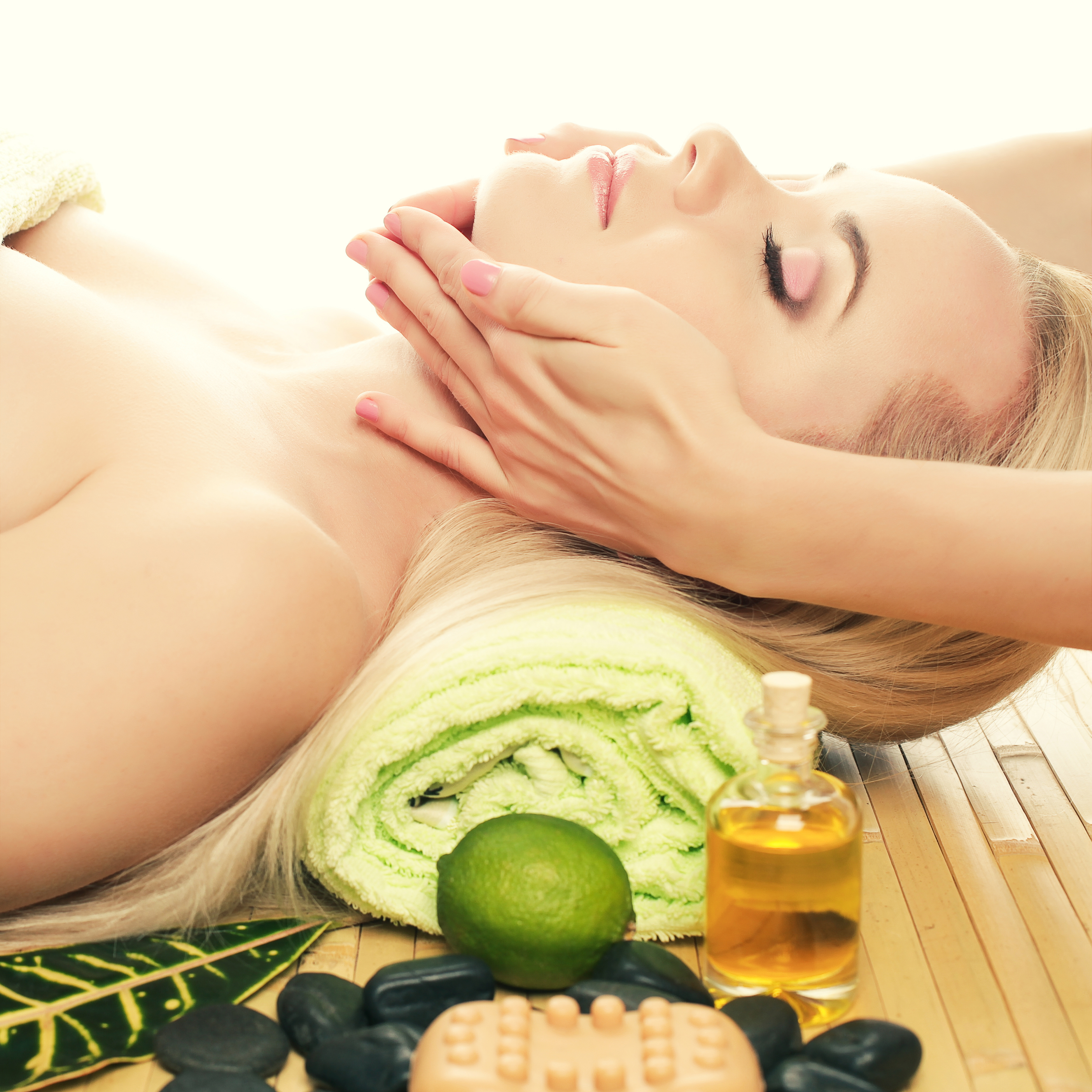 A beautiful young woman receiving facial massage at a spa salon